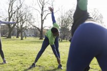 Mann dehnt sich, trainiert im grünen Park — Stockfoto