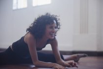 Feliz, confiante jovem dançarina alongamento no estúdio de dança — Fotografia de Stock