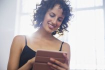 Усміхнена молода жінка використовує цифровий планшет — стокове фото