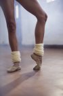 Ballet dancer stretching toes in dance studio — Stock Photo
