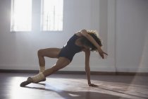 Грациозная молодая танцовщица, практикующая в танцевальной студии — стоковое фото