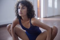 Fokussierte, starke junge Tänzerin dehnt sich im Tanzstudio — Stockfoto