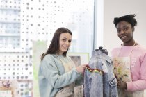 Retrato sonriente adolescentes diseñando chaqueta de mezclilla en la clase de diseño de moda - foto de stock