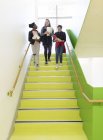 Chicas de secundaria bajando escaleras - foto de stock