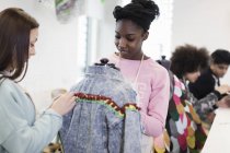 Adolescentes meninas projetando jaqueta de ganga na classe de design de moda — Fotografia de Stock