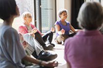 Активні літні люди, які медитують в колі — стокове фото