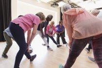 Active seniors stretching legs in exercise class — Stock Photo