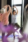 Sourire active femme âgée exercice, pratique de pose d'arbre de yoga — Photo de stock