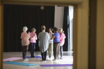 Активні літні люди практикують йогу в колі — стокове фото
