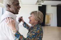 Счастливая активная старшая пара танцует в танцевальной студии — стоковое фото