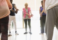 Активні літні люди розтягують зап'ястя в класі фізичних вправ — стокове фото