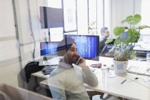 Programador informático indio en turbante hablando en el teléfono inteligente en la oficina - foto de stock