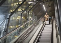 Бизнесмен с чемоданом на городском эскалаторе — стоковое фото