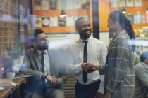 Smiling business people handshaking in cafe — Stock Photo