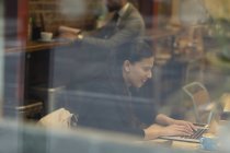 Empresária sorridente trabalhando no laptop no café — Fotografia de Stock