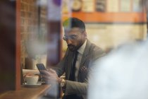 Бізнесмен, використовуючи смарт-телефону, працюють в кафе — стокове фото