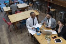 Negócios falando e comendo, trabalhando no café — Fotografia de Stock