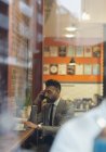 Бизнесмен разговаривает на смартфоне, работает в кафе — стоковое фото