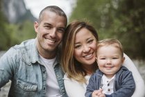 Retrato sonriente padres y bebé hijo - foto de stock
