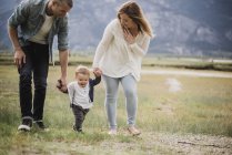 Родители, гуляющие с маленьким сыном в сельской местности — стоковое фото