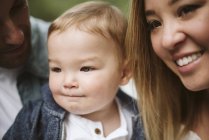 Close up smiling parents and cute baby son looking away — Stock Photo