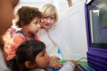 Crianças curiosas usando computador no centro de ciências — Fotografia de Stock