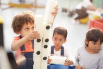 Crianças curiosas empilhando grandes dominós em exposição interativa no centro de ciência — Fotografia de Stock