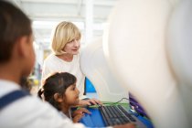 Учитель и школьница с помощью компьютера в научном центре — стоковое фото