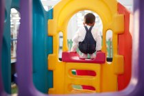 Boy playing on slide indoors — Stock Photo