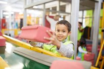 Ritratto sorridente ragazzo impilare mattoni di schiuma a mostra costruzione interattiva nel centro scientifico — Foto stock