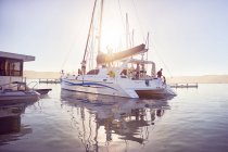 Catamaran with people in sunny ocean harbor — Stock Photo