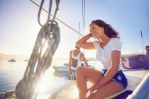 Happy young woman relaxing on sunny boat — Stock Photo
