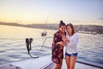 Jovens mulheres usando telefone inteligente no catamarã — Fotografia de Stock