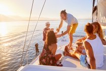 Amigos relajarse, beber champán en barco soleado - foto de stock