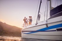 Amici che bevono sul catamarano al tramonto — Foto stock