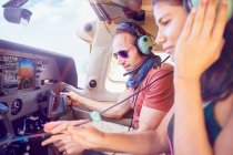 Pilot and copilot flying airplane, checking navigational equipment — Stock Photo