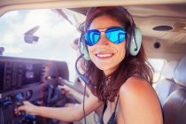 Портрет усміхнений, впевнена молода жінка літає літаком — стокове фото
