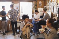 Creativi uomini d'affari con cane che lavorano e mangiano in ufficio — Foto stock