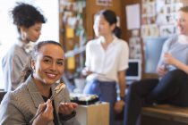 Портрет улыбающейся, уверенной в себе творческой предпринимательницы, поедающей суши в офисе — стоковое фото