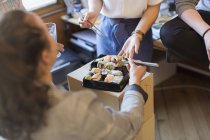 Business people eating sushi in office — Stock Photo