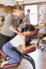 Empresária criativa recebendo massagem da massagista no escritório — Fotografia de Stock
