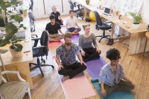 Спітнілі креативні бізнесмени медитують в офісі — стокове фото