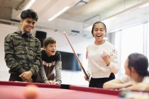 Happy teenagers playing pool in community center — Stock Photo