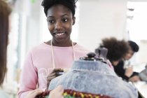 Menina adolescente sorridente projetando jaqueta de ganga na classe de design de moda — Fotografia de Stock