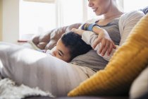 Affectionate mother and son cuddling on sofa — Stock Photo