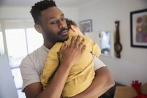 Affectionate father holding tired baby son — Stock Photo