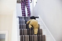 Baby boy crawling up stairs — Stock Photo