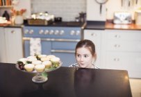 Jolie fille qui regarde les tartes de Noël sur le comptoir de cuisine — Photo de stock