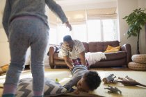 Playful father and children in living room — Stock Photo
