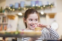 Smiling girl eating Christmas cupcake — Stock Photo